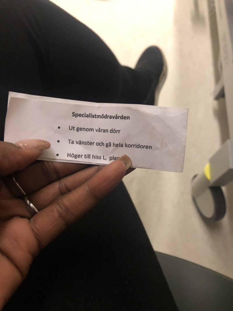 Lovette Jallow's hand holding hospital information, indicating her support and advocacy for Jeanine's medical care.