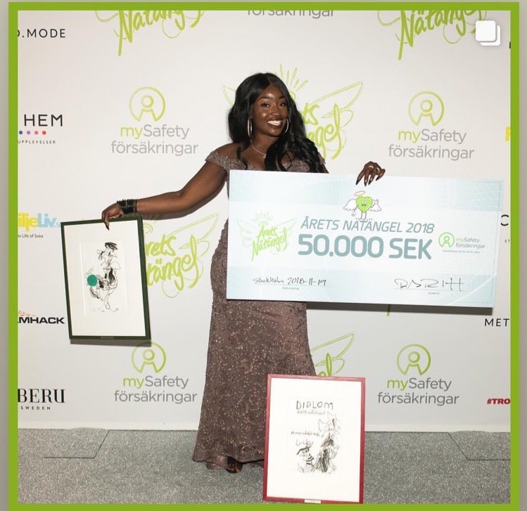 Lovette Jallow posing with the Netangel of the year (Årets Nätängel) award and the paintings included in the award.