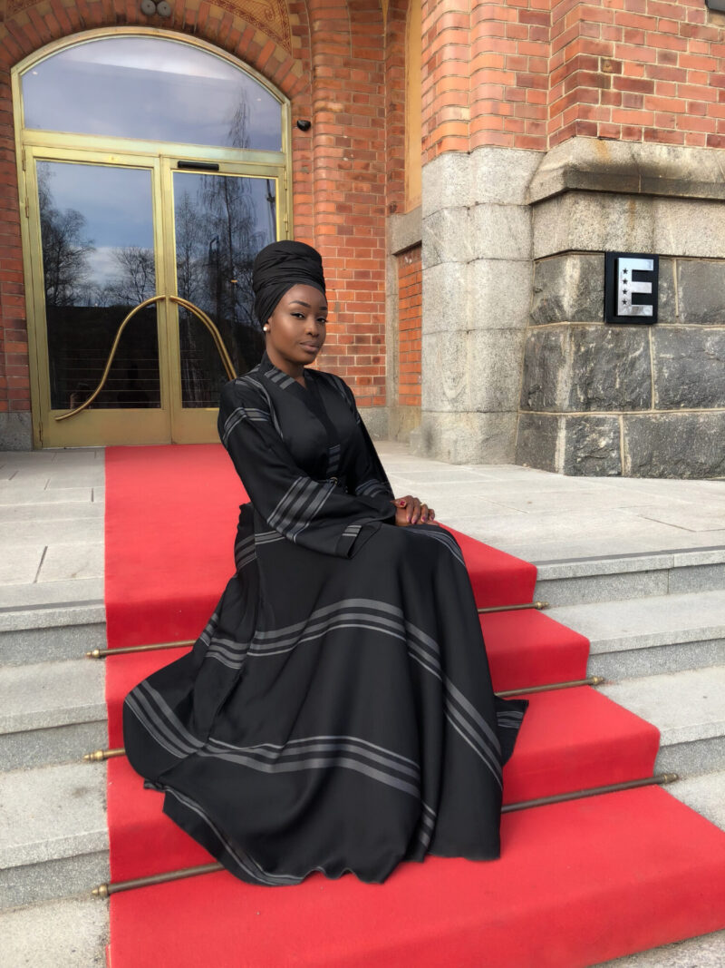 Black Woman in headwrap sitting on staird