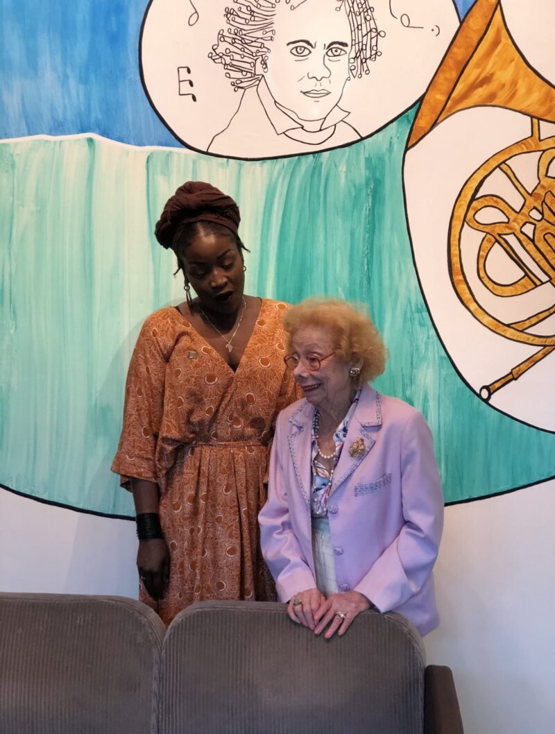 a woman standing next to a older woman