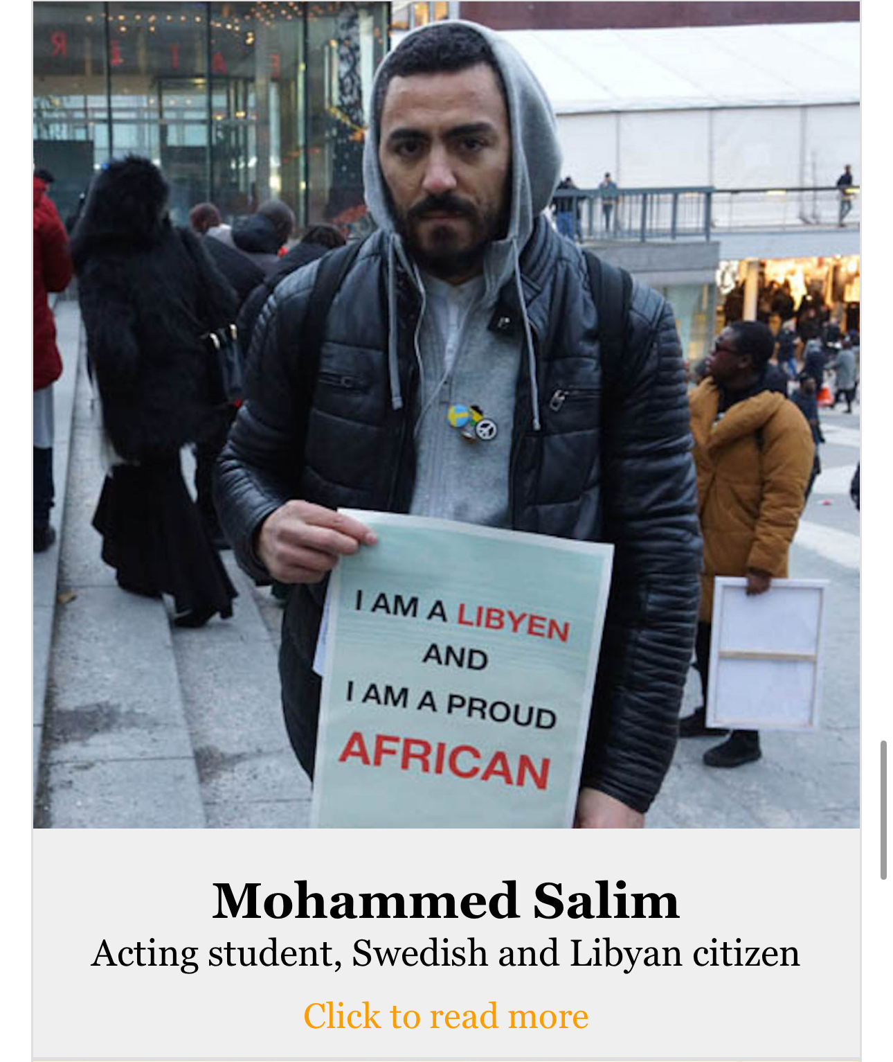Man holding sign that says “I am Libyan and proud African”