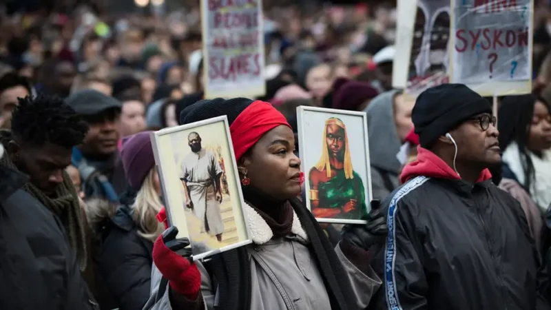 a woman holding up pictures of people